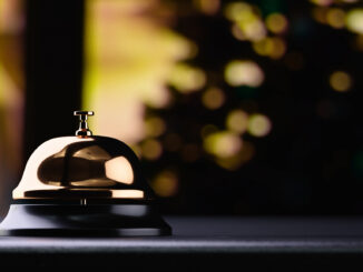 Golden reception bell on black table with shallow depth of field black background. Service concept