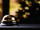 Golden reception bell on black table with shallow depth of field black background. Service concept